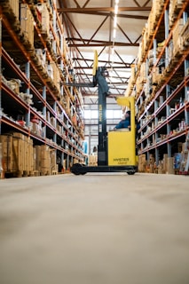 A yellow forklift in a large warehouse