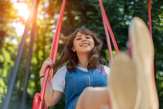A woman sitting on a swing in a park