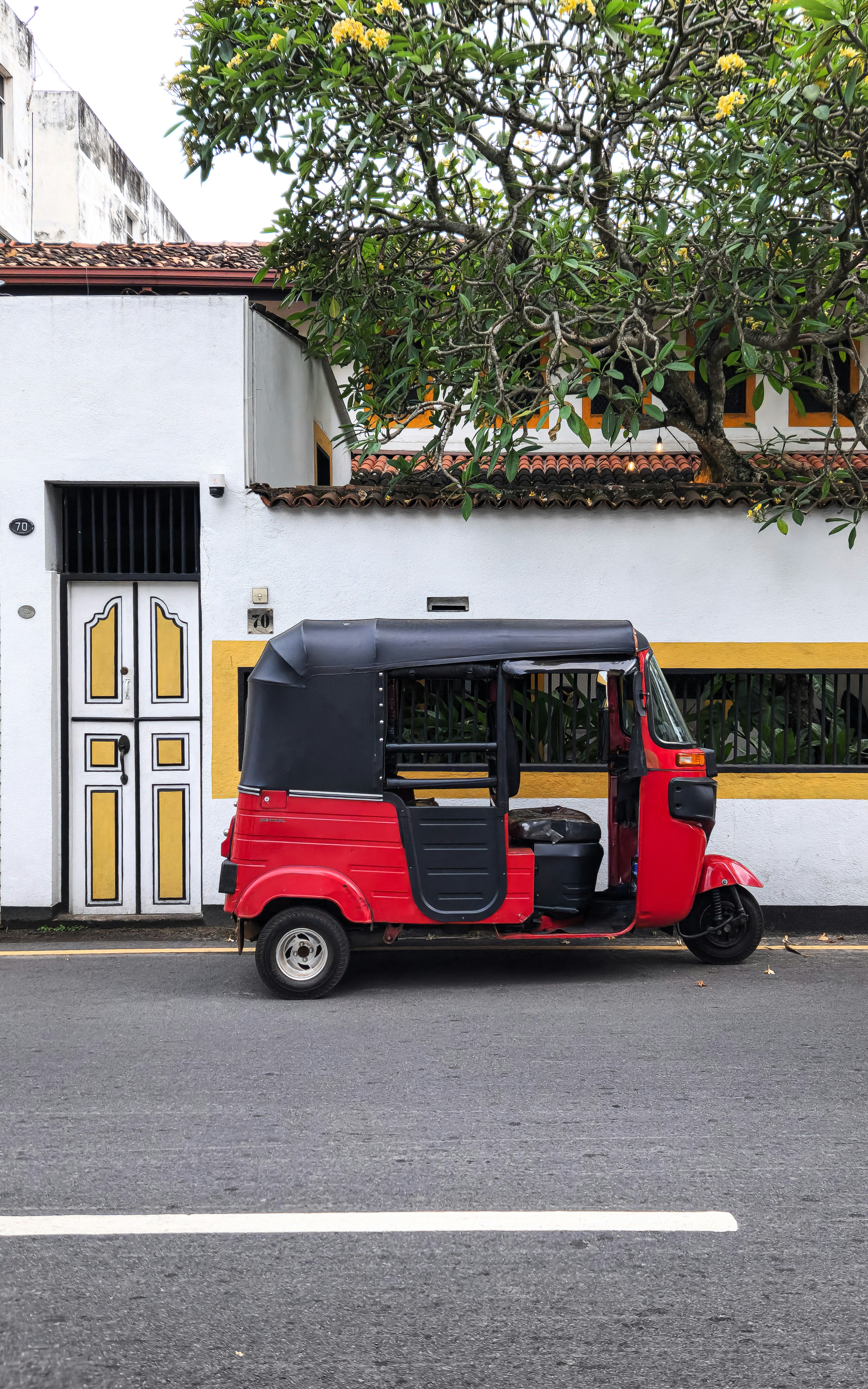 A red and black golf cart parked in front of a building