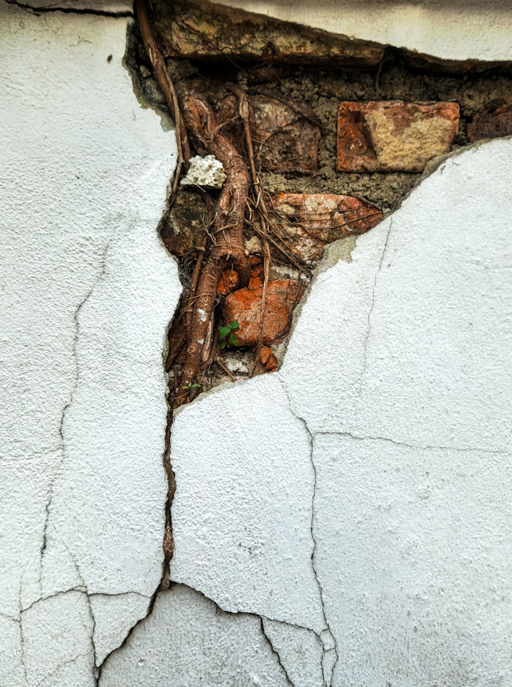 Wall with serious crack exposing underlying brick, showing when to worry about structural damage