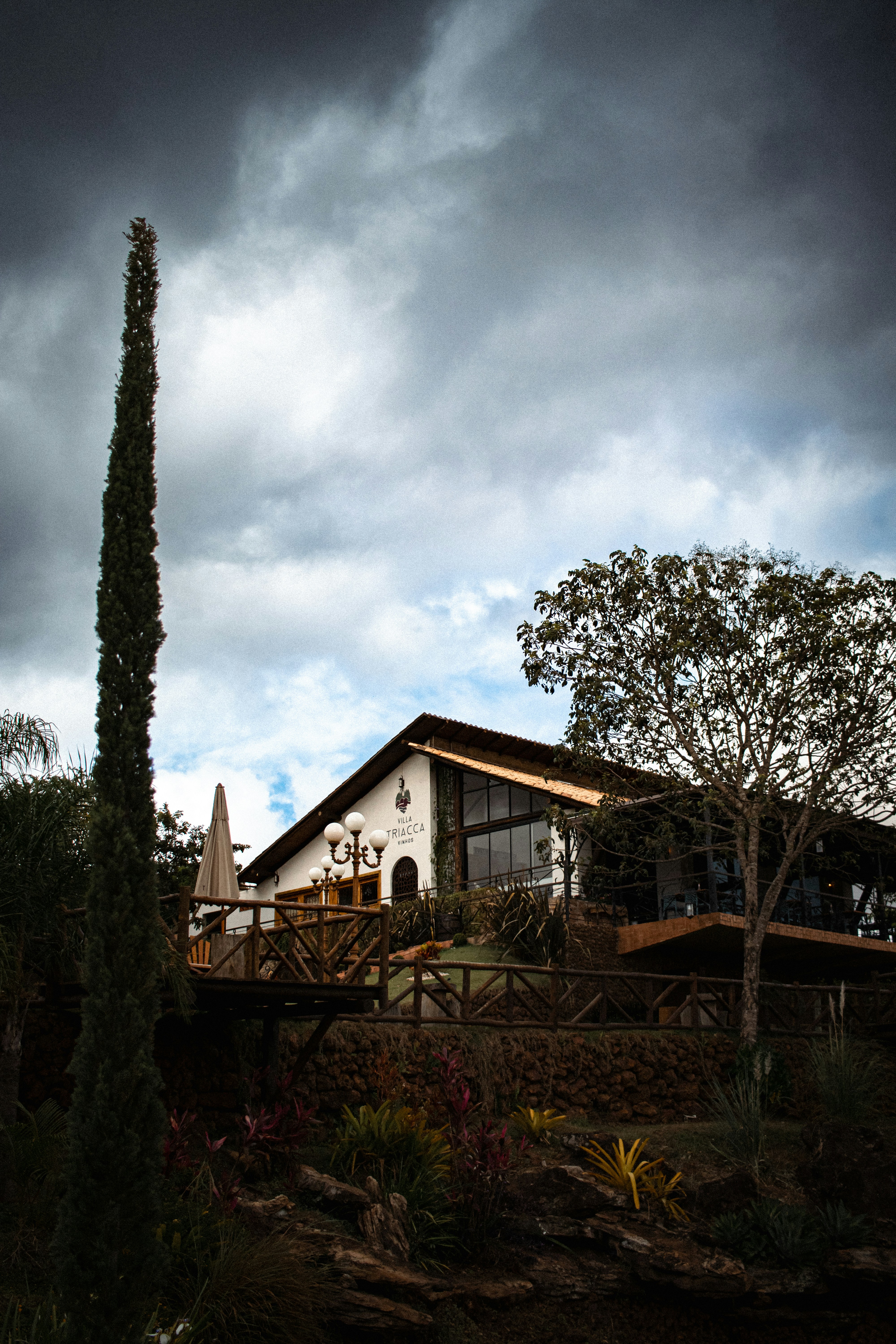 A house sitting on top of a hill under a cloudy sky