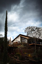 A house sitting on top of a hill under a cloudy sky