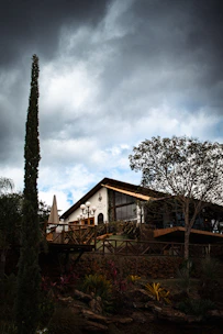A house sitting on top of a hill under a cloudy sky