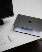 An apple computer sitting on top of a white desk