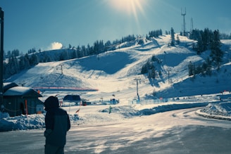 A person standing in front of a snow covered mountain