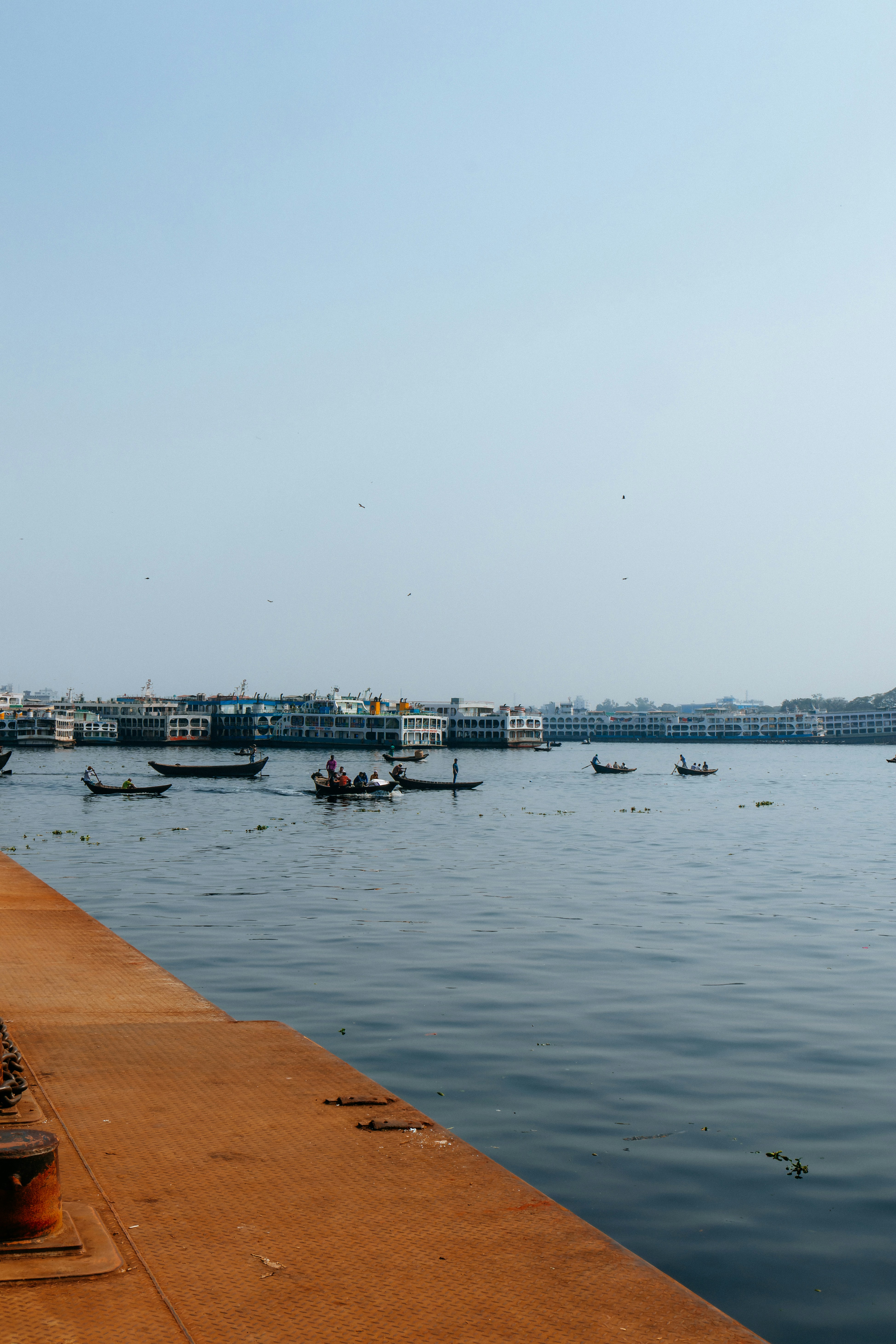 A bench sitting on the edge of a pier next to a body of water