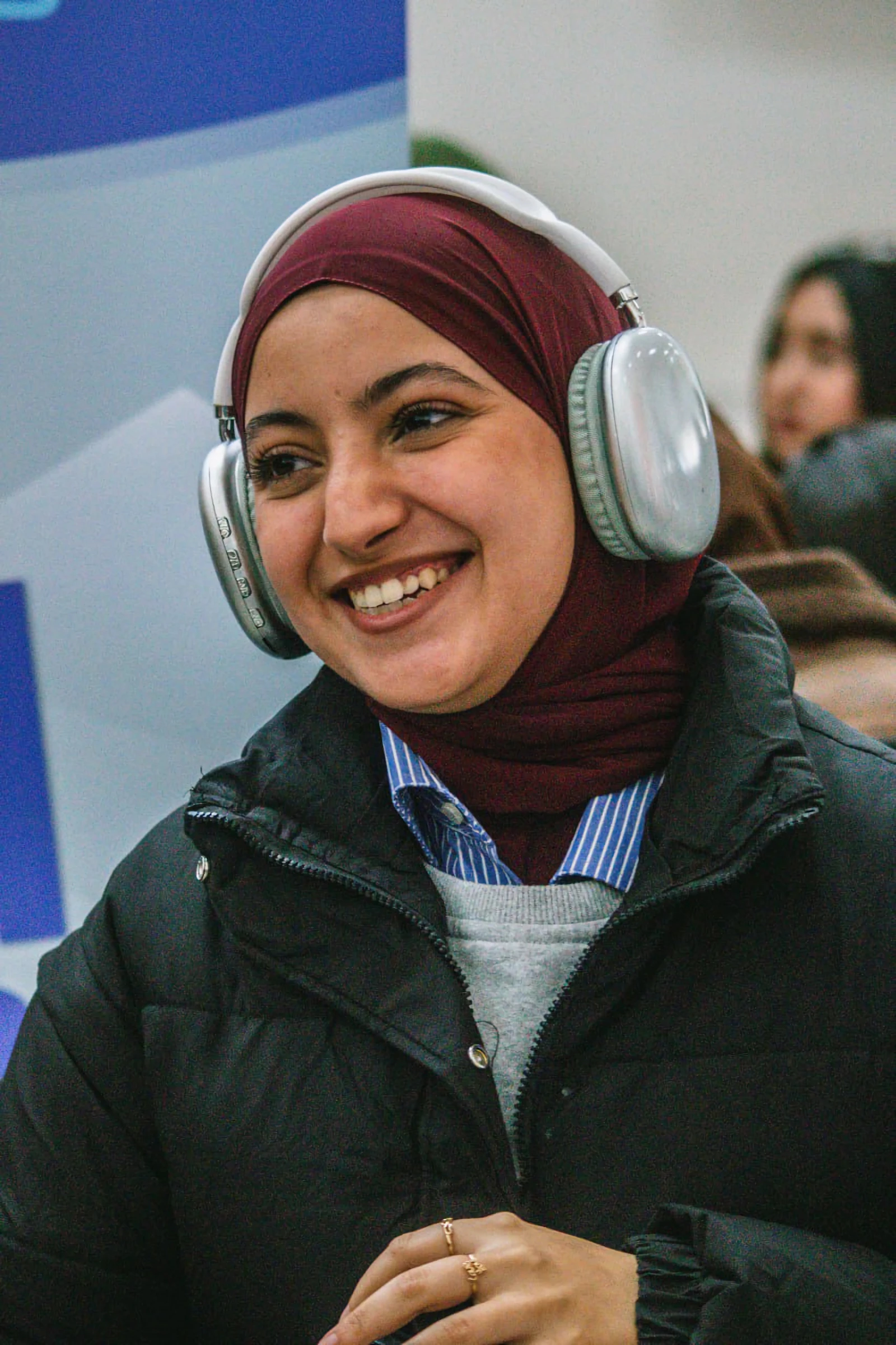 Una mujer con audífonos, sonriendo