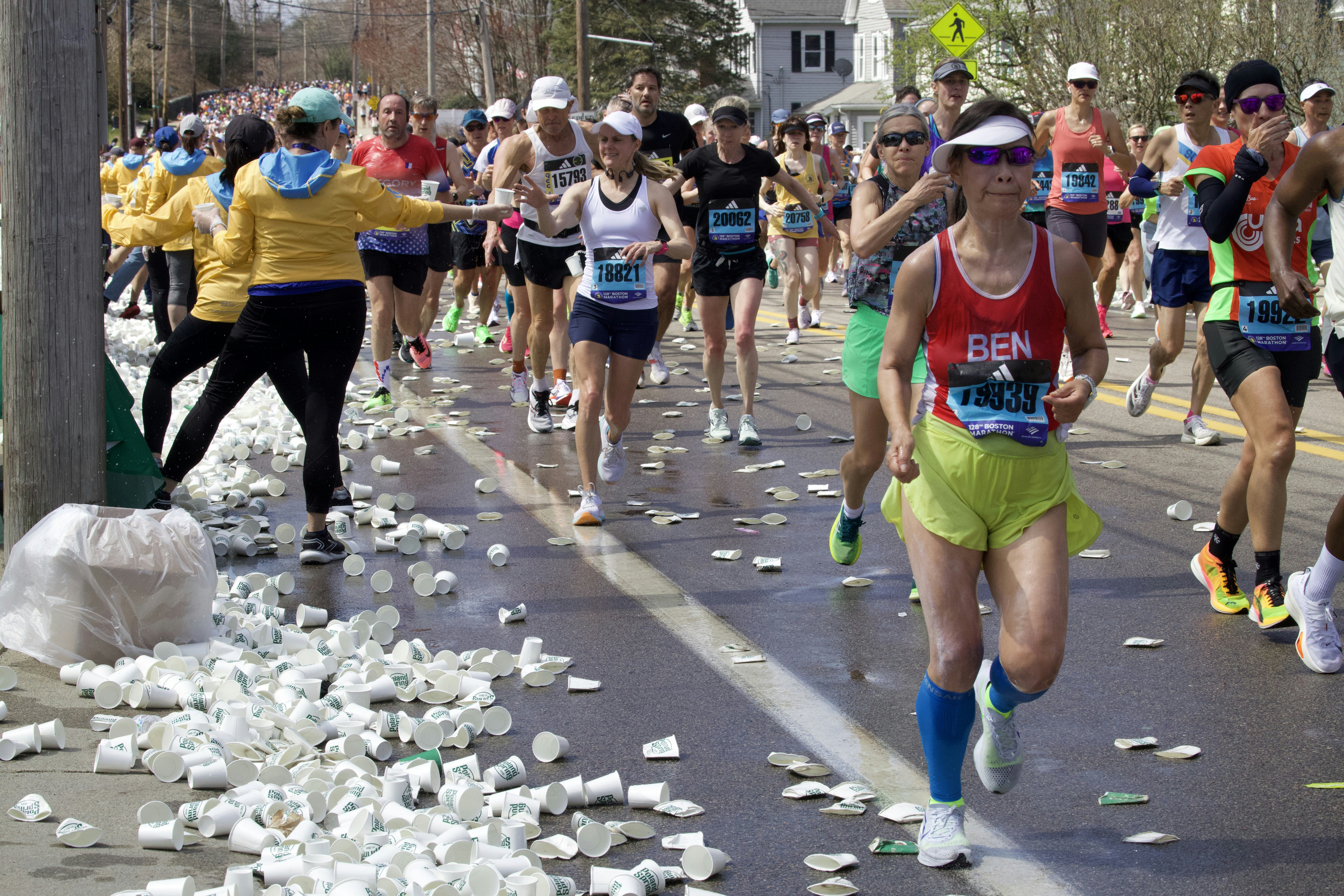A large group of people running down a street - lifestyle marathon wellness concept for fitness and health