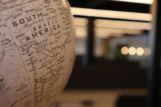 A close up of a globe with a building in the background