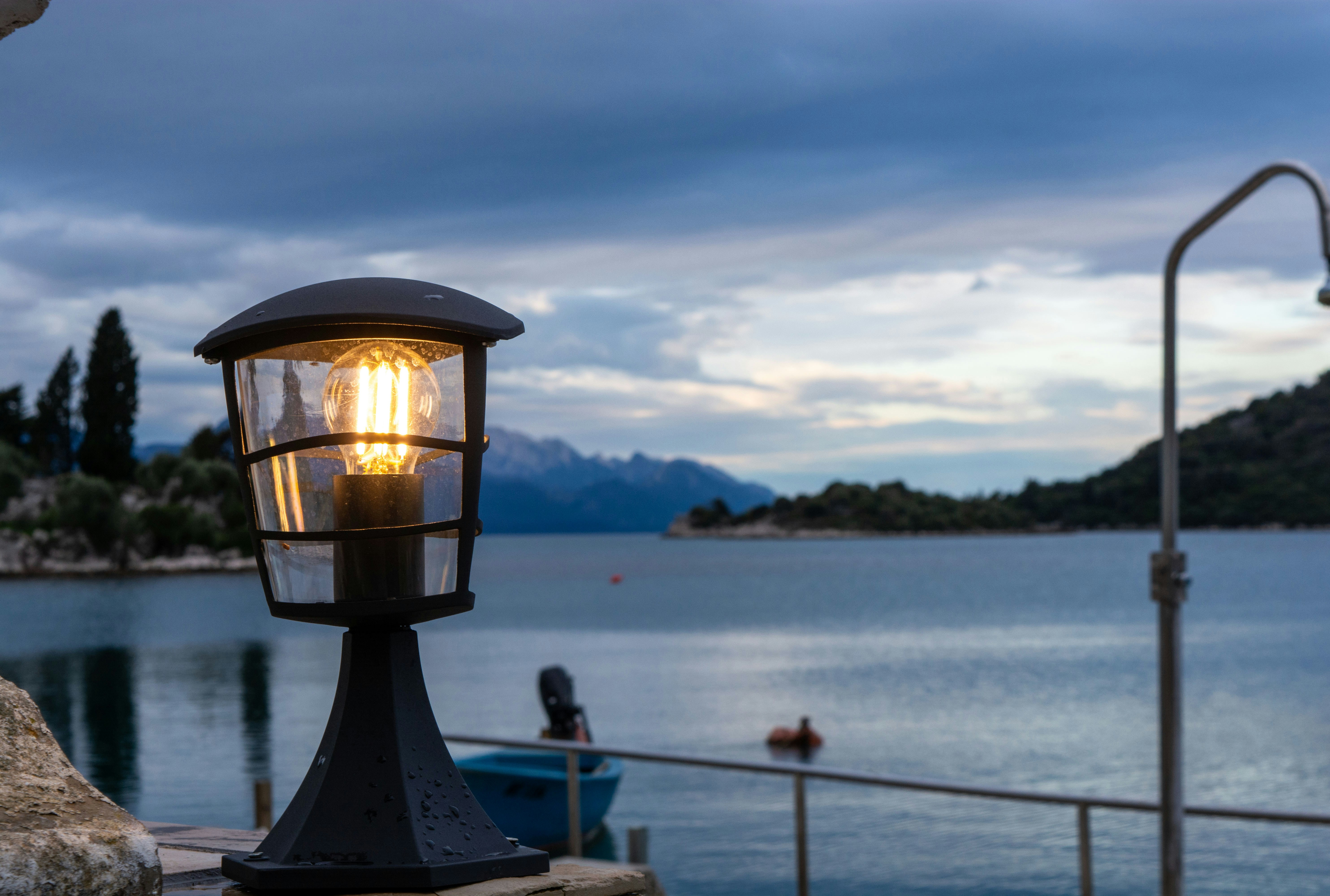 A street light sitting next to a body of water photo – Free Scenery ...