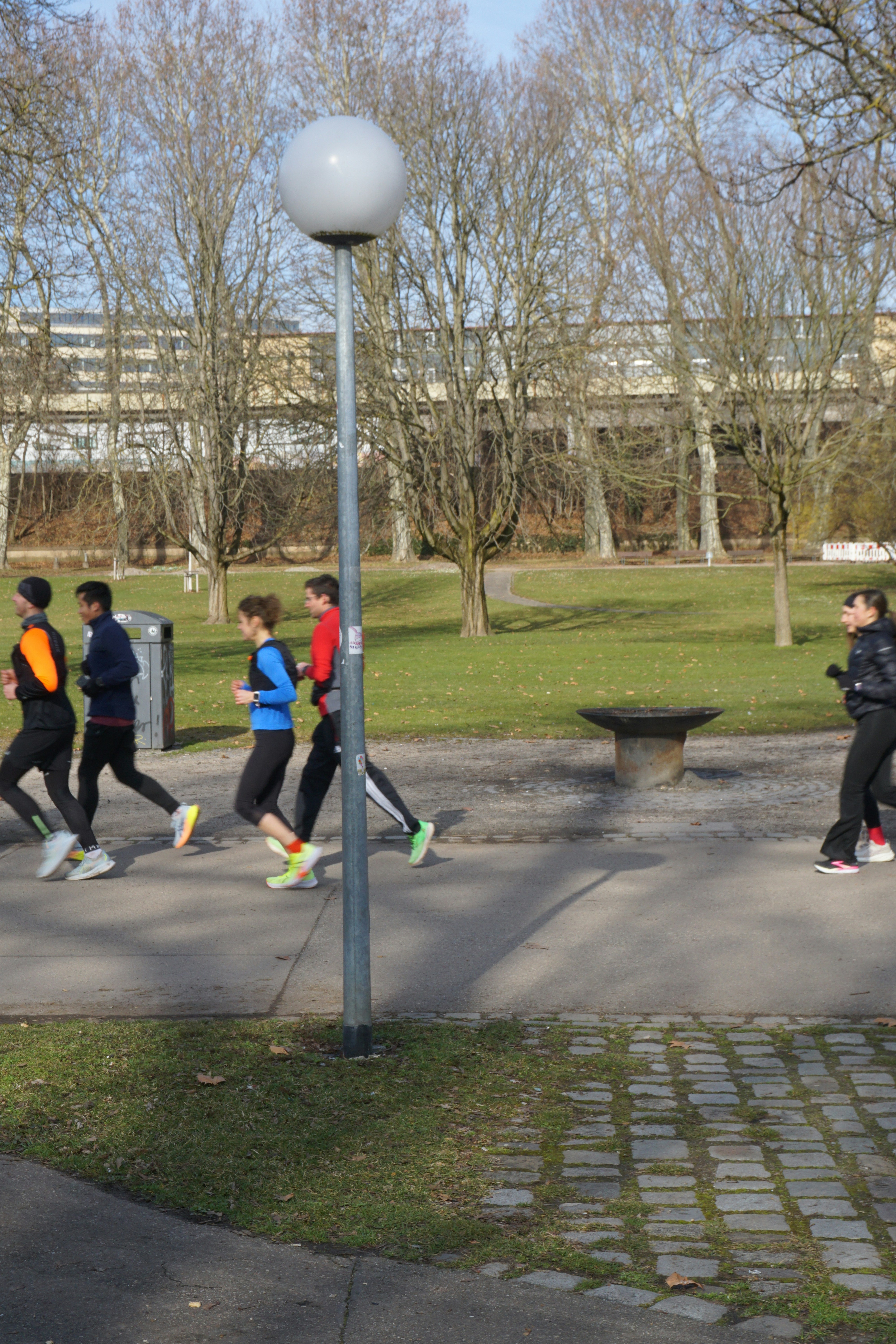 A group of people walking down a sidewalk