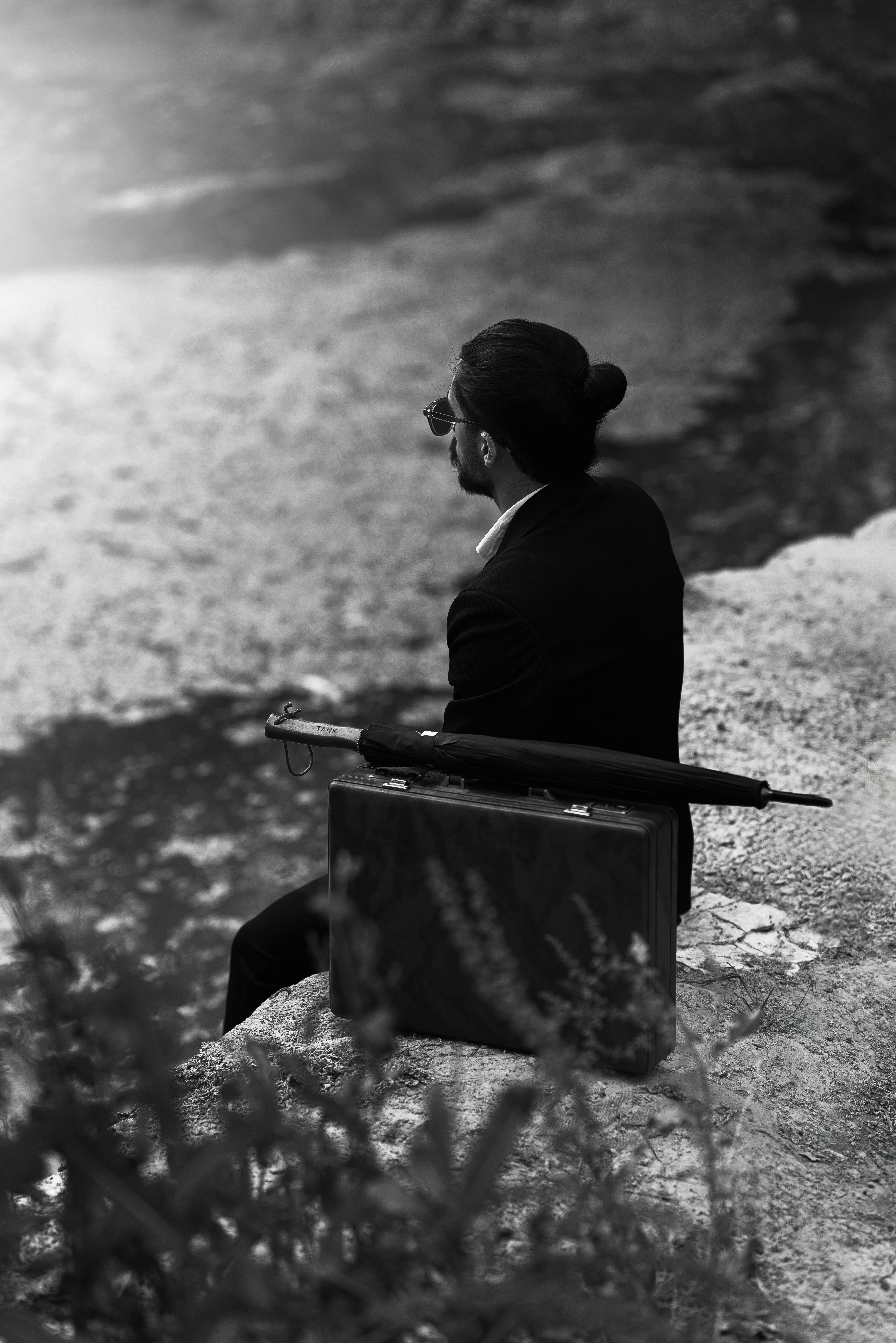 A man sitting on a bench next to a body of water