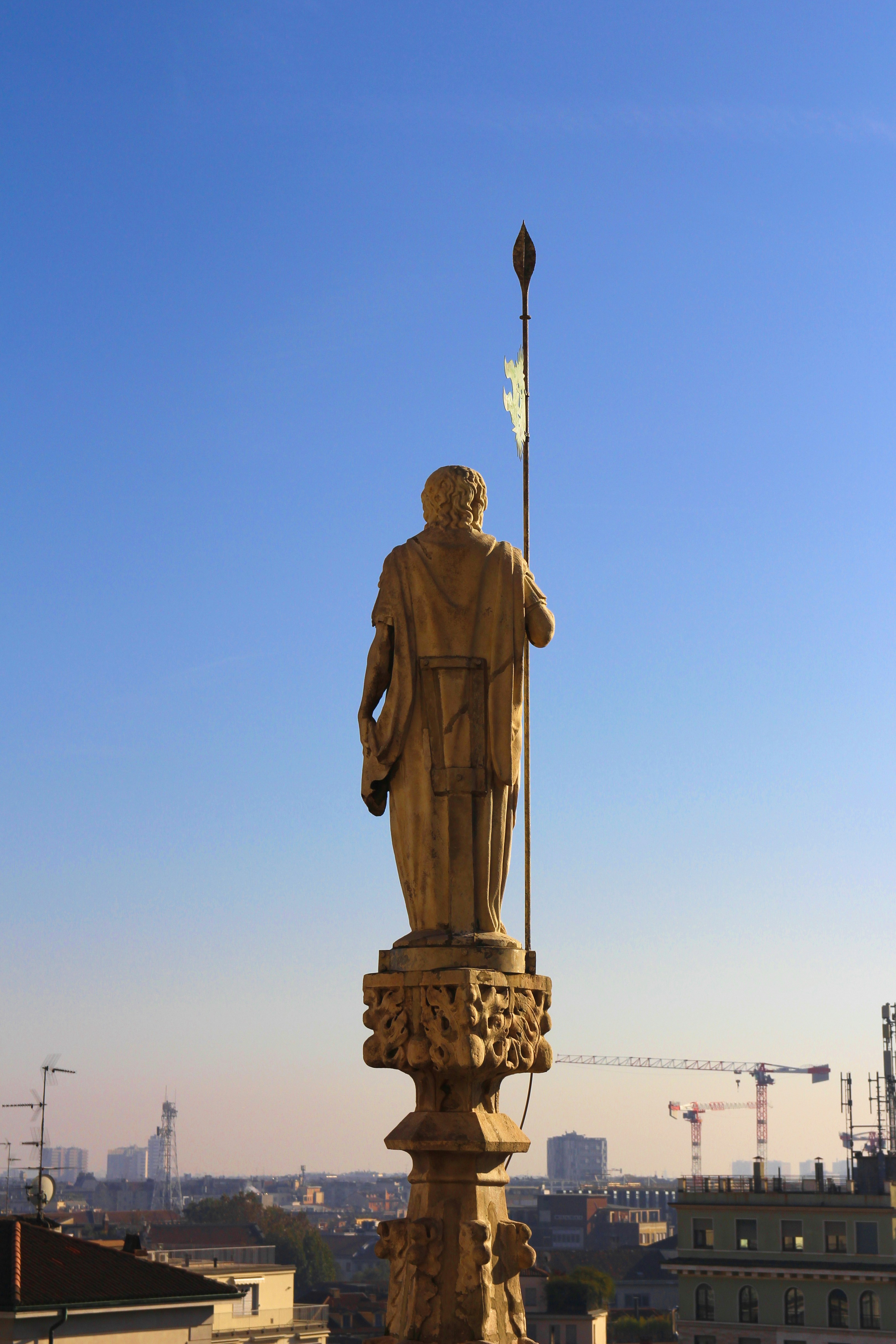 A statue of a man holding a flag on top of a building