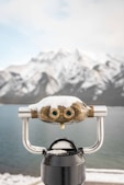 A close up of a telescope with a mountain in the background