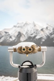 A close up of a telescope with a mountain in the background