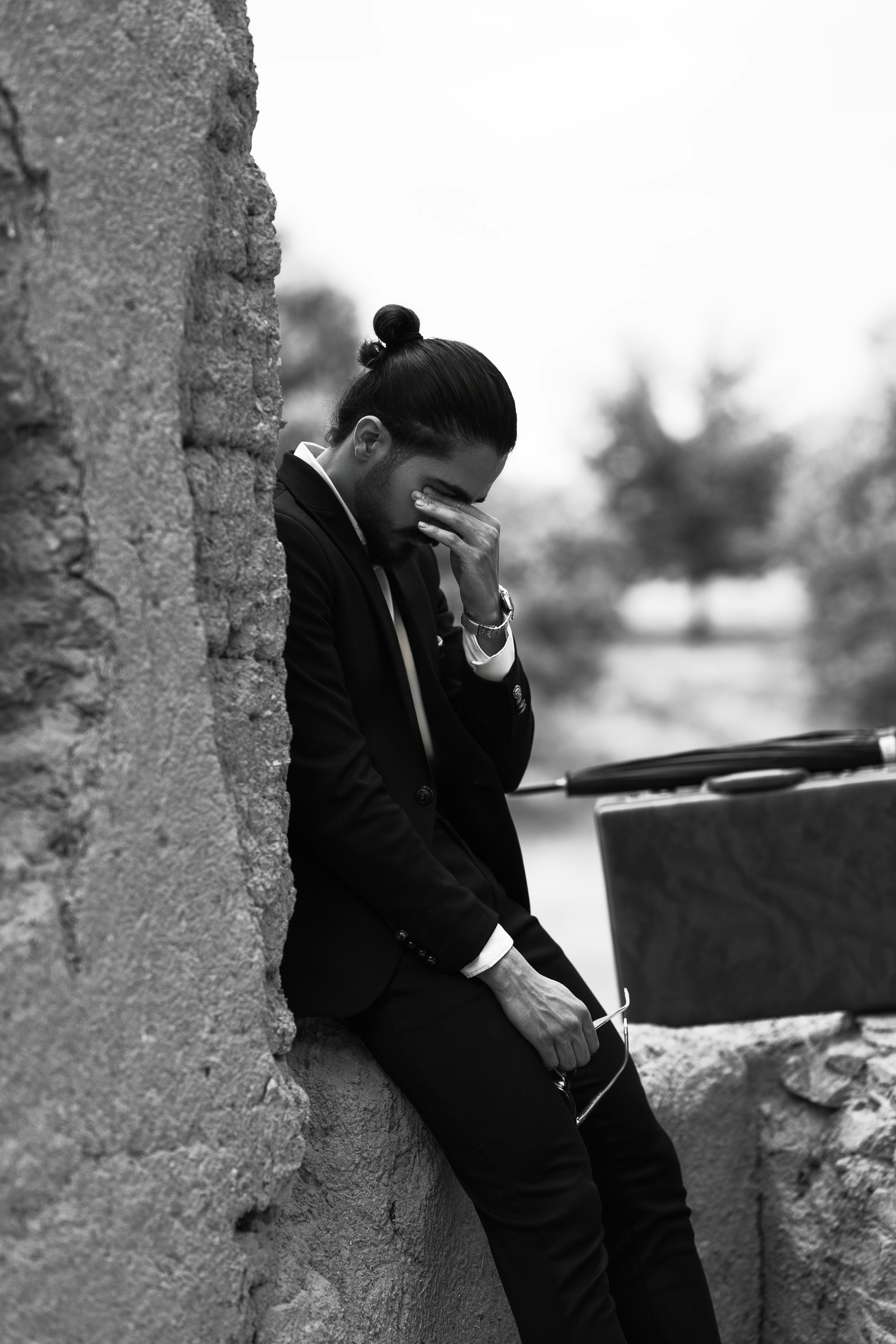 A man sitting on a wall talking on a cell phone