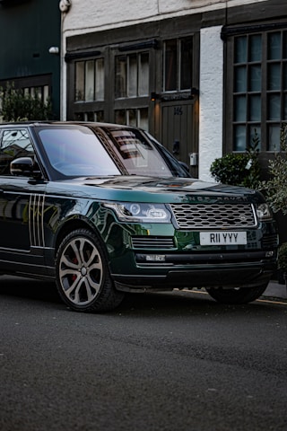 A green range rover autobiography parked on the side of the road