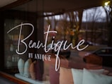 A window with a sign that reads beautique by anyone