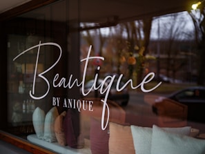 A window with a sign that reads beautique by anyone