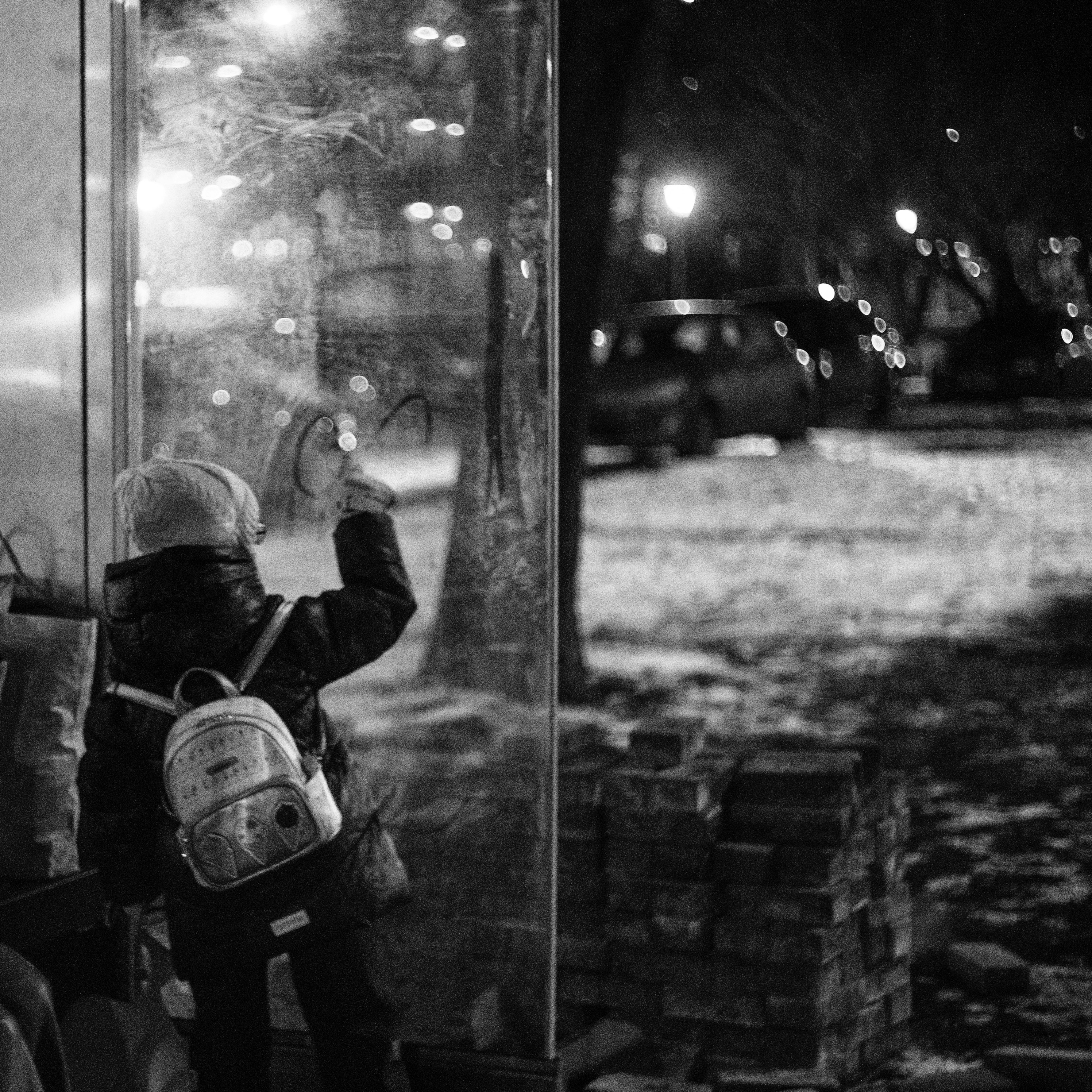A person sitting on a bench in front of a window