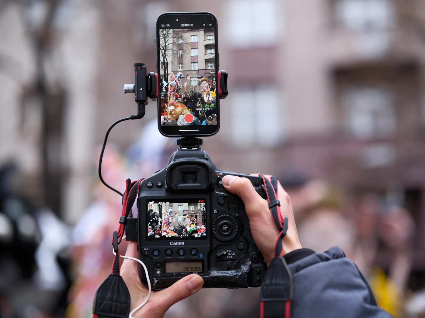 Photographer recording with a phone and a camera