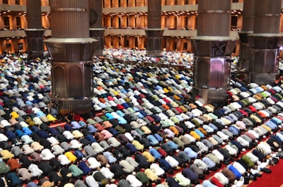 Worshippers pray together inside a grand mosque.