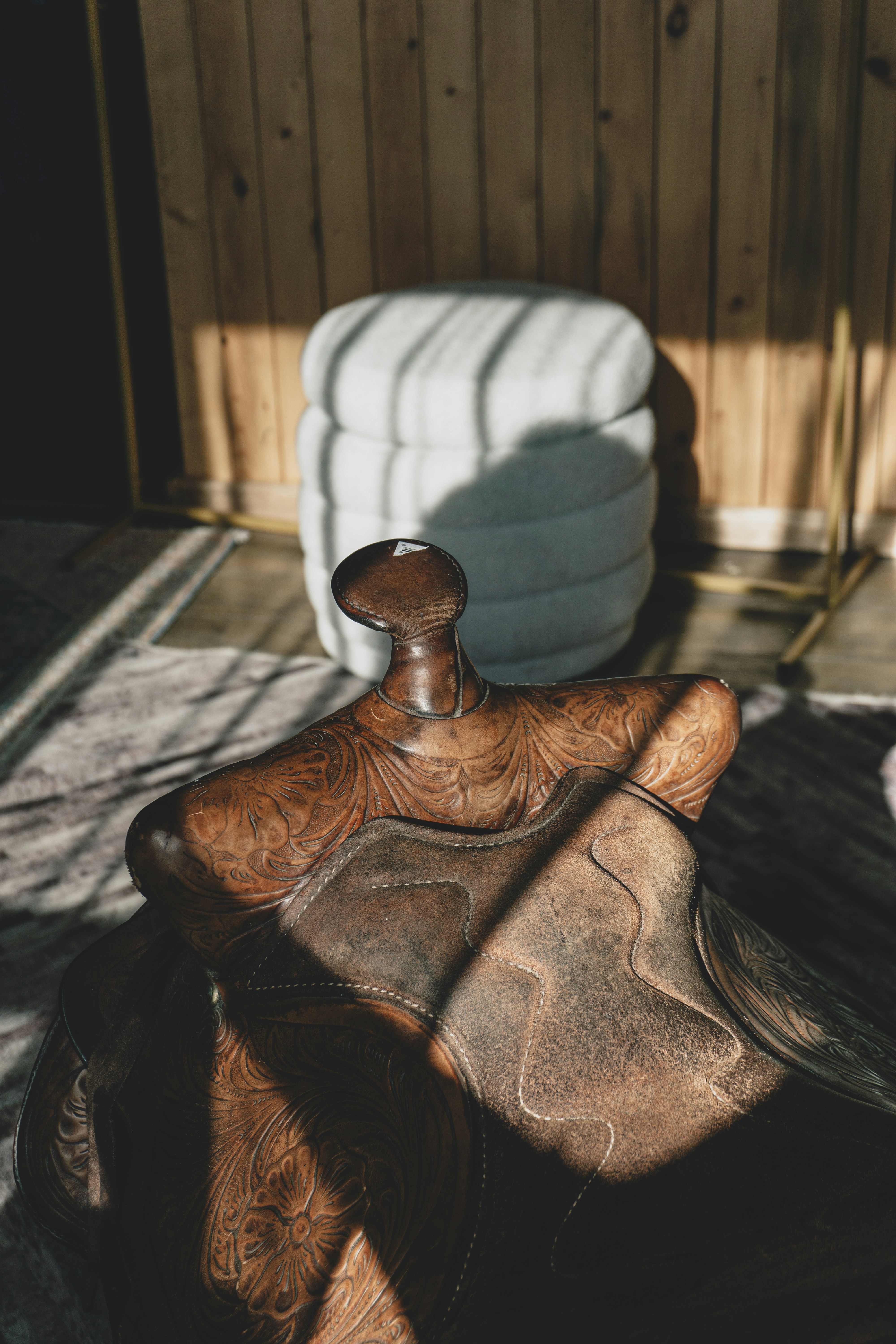 A western saddle sits in the sunlight.
