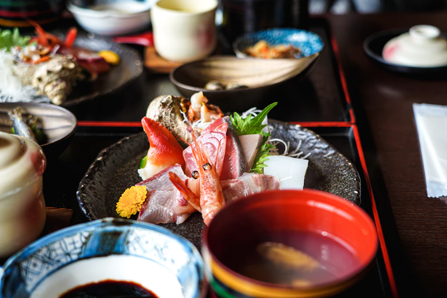 漆器と土地の器に盛り付けられた会席料理