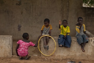 Children play together outdoors with a hoop.