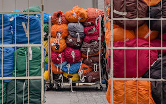 A bunch of bags are stacked on a cart