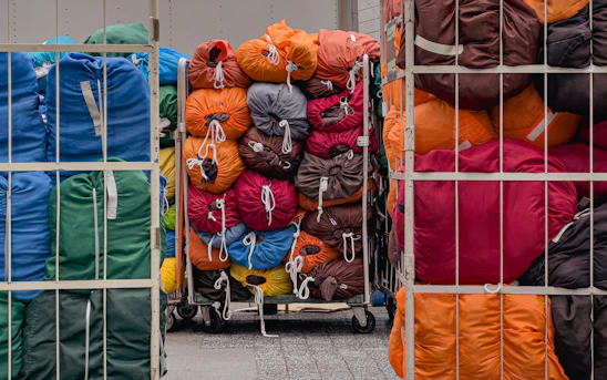 A bunch of bags are stacked on a cart