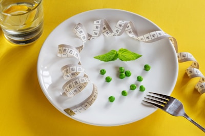 A white plate topped with peas and measuring tape