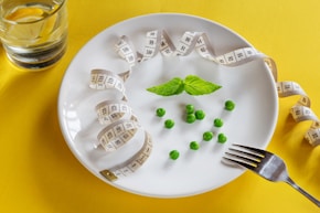A white plate topped with peas and measuring tape