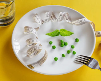 A white plate topped with peas and measuring tape
