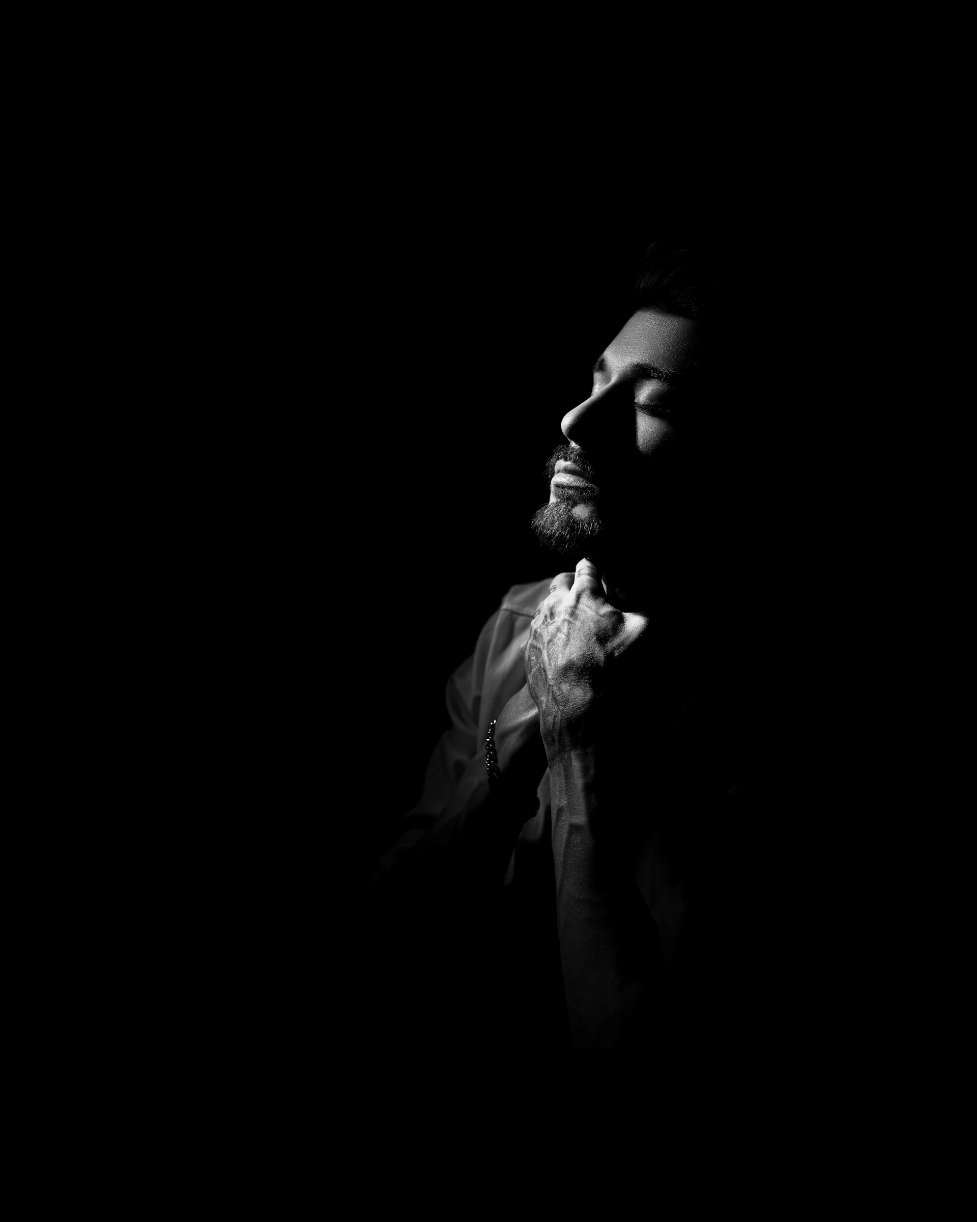 Man is shrouded in shadow, with a soft glow.