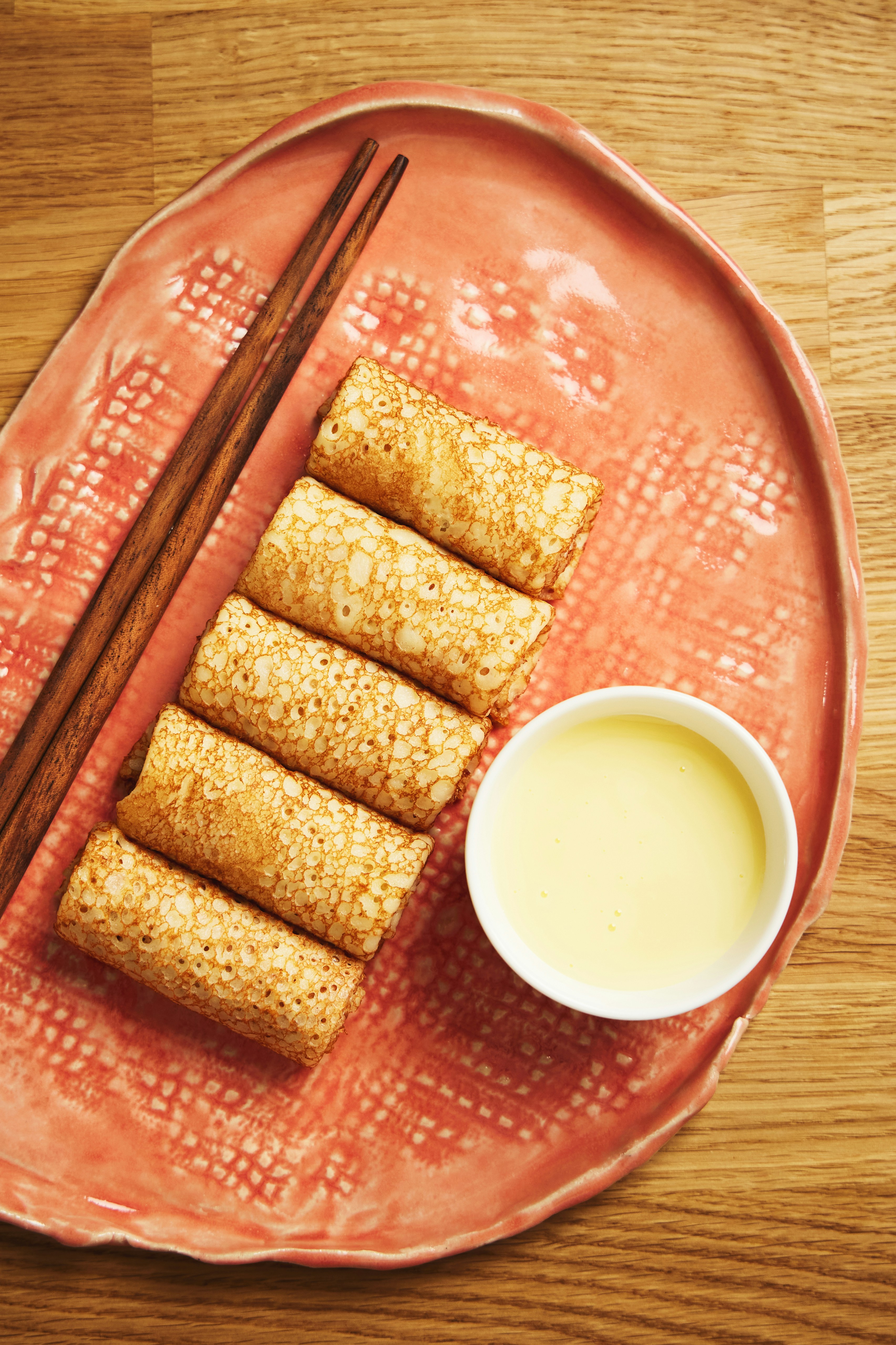 Um prato de comida com pauzinhos e uma tigela de leite