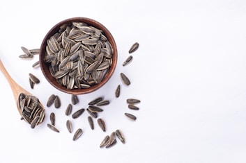 Sunflower seeds in a wooden bowl and spoon.