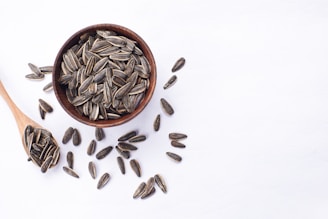 Sunflower seeds in a wooden bowl and spoon.
