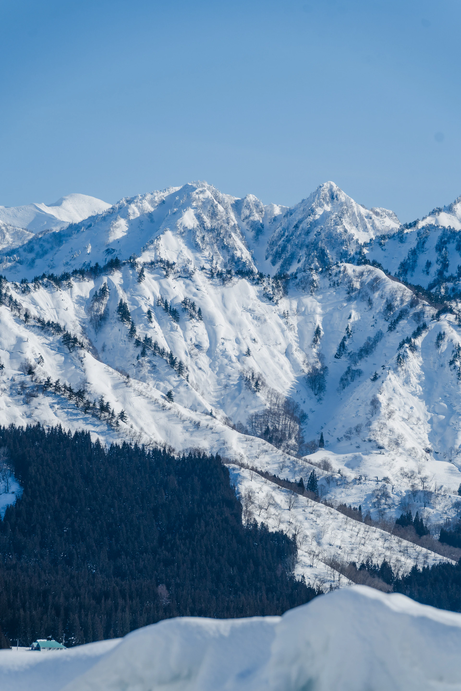 Snow-covered mountains under a bright, clear sky.