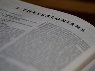 A close up of an open bible with the word thessalonians on it