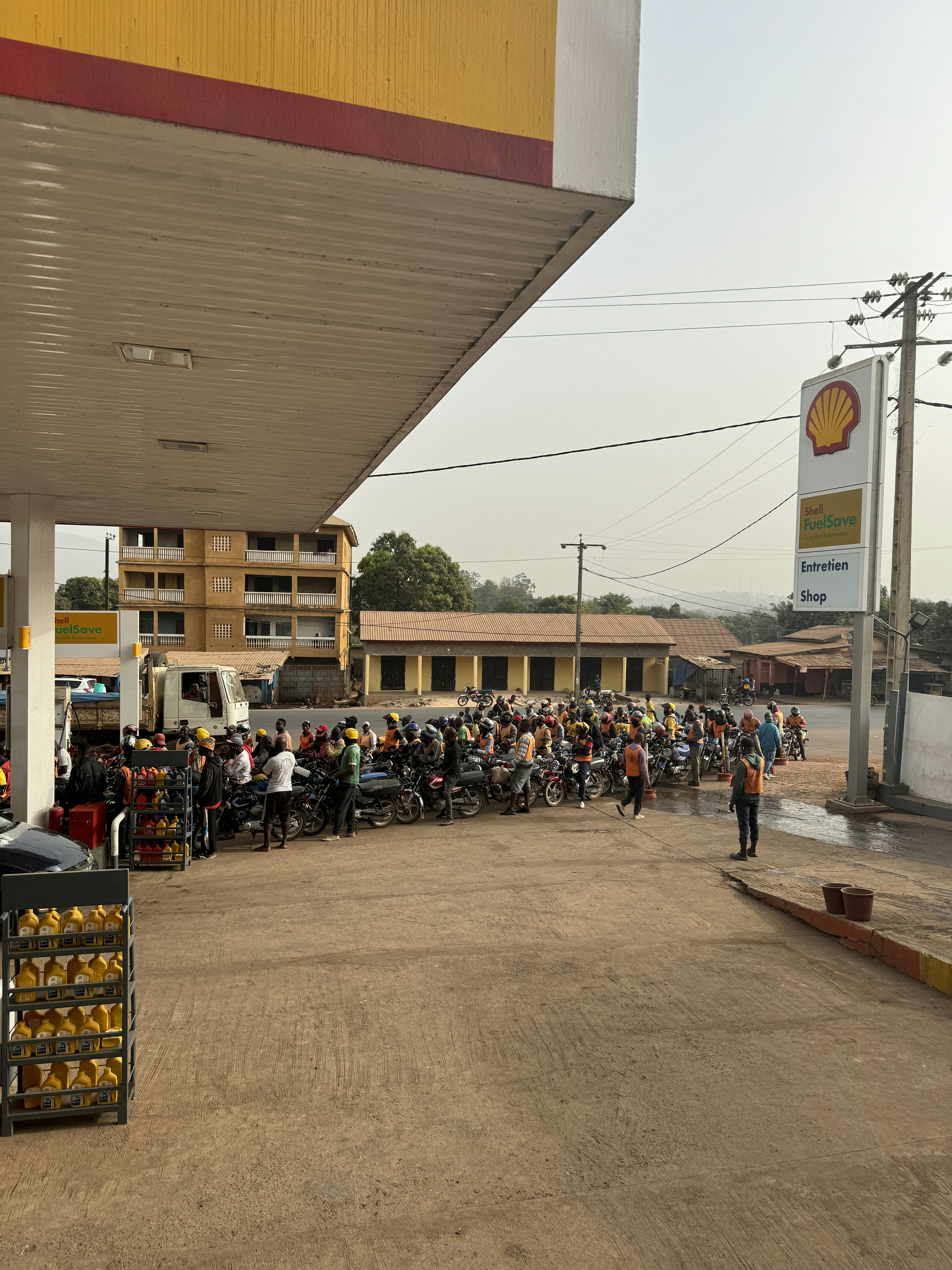 ガソリンスタンドの前に立つ大勢の人々