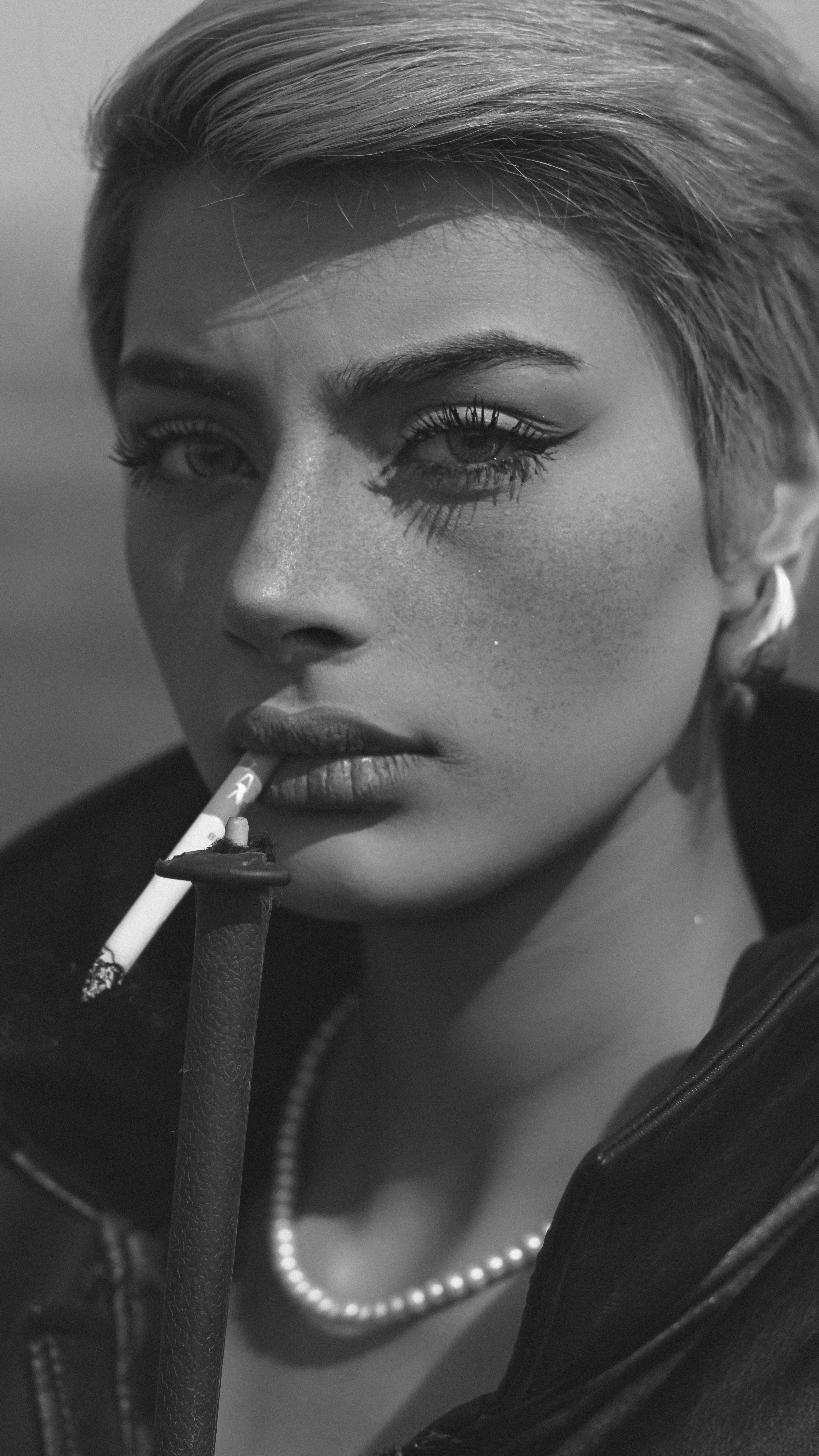 A woman smokes a cigarette, posing in black and white. photo – Free Image  on Unsplash