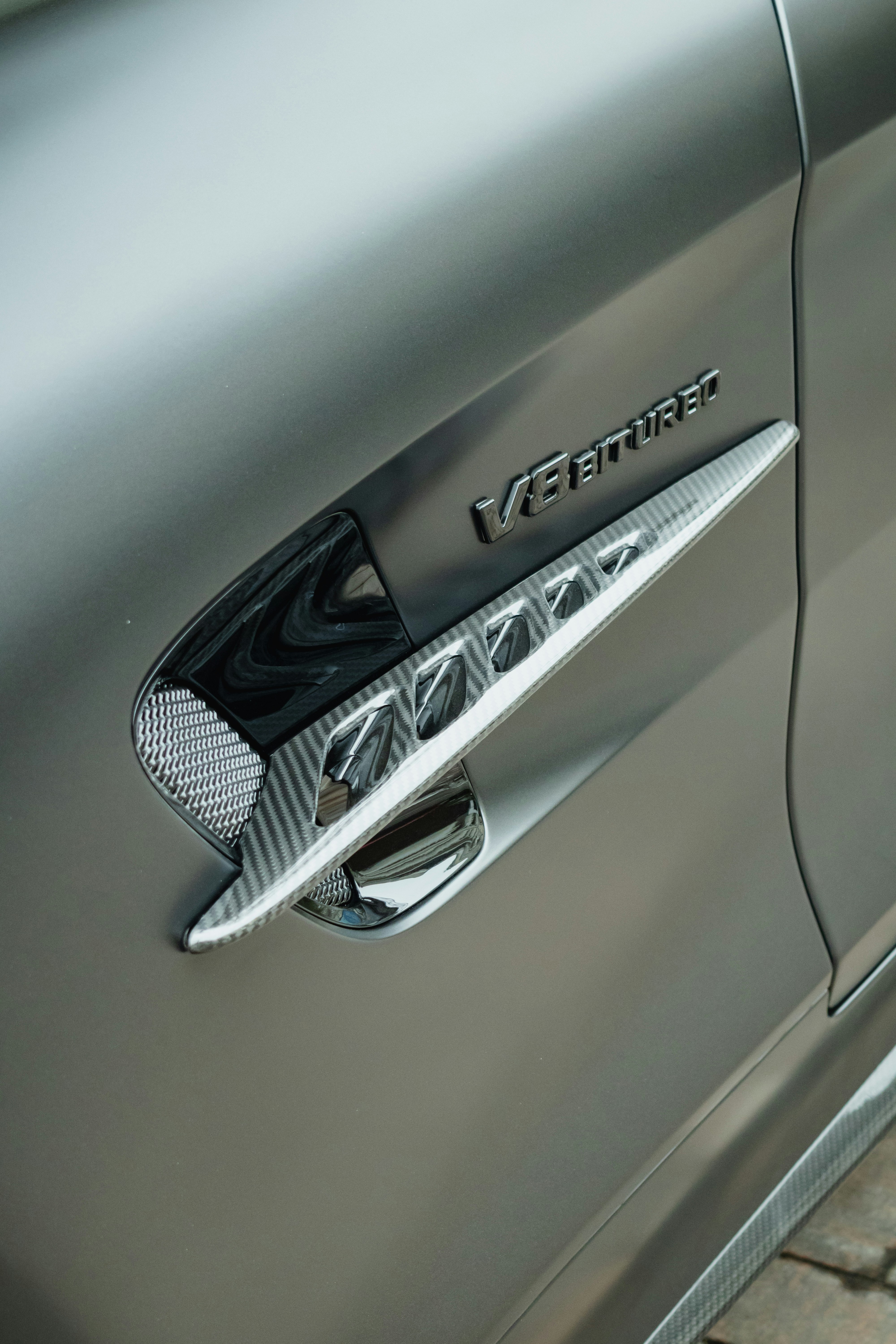 A v8 biturbo emblem adorns a car's fender.