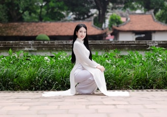 Vietnam’s National Dress: The Elegance of the Ao Dai A woman sitting in front of a building
