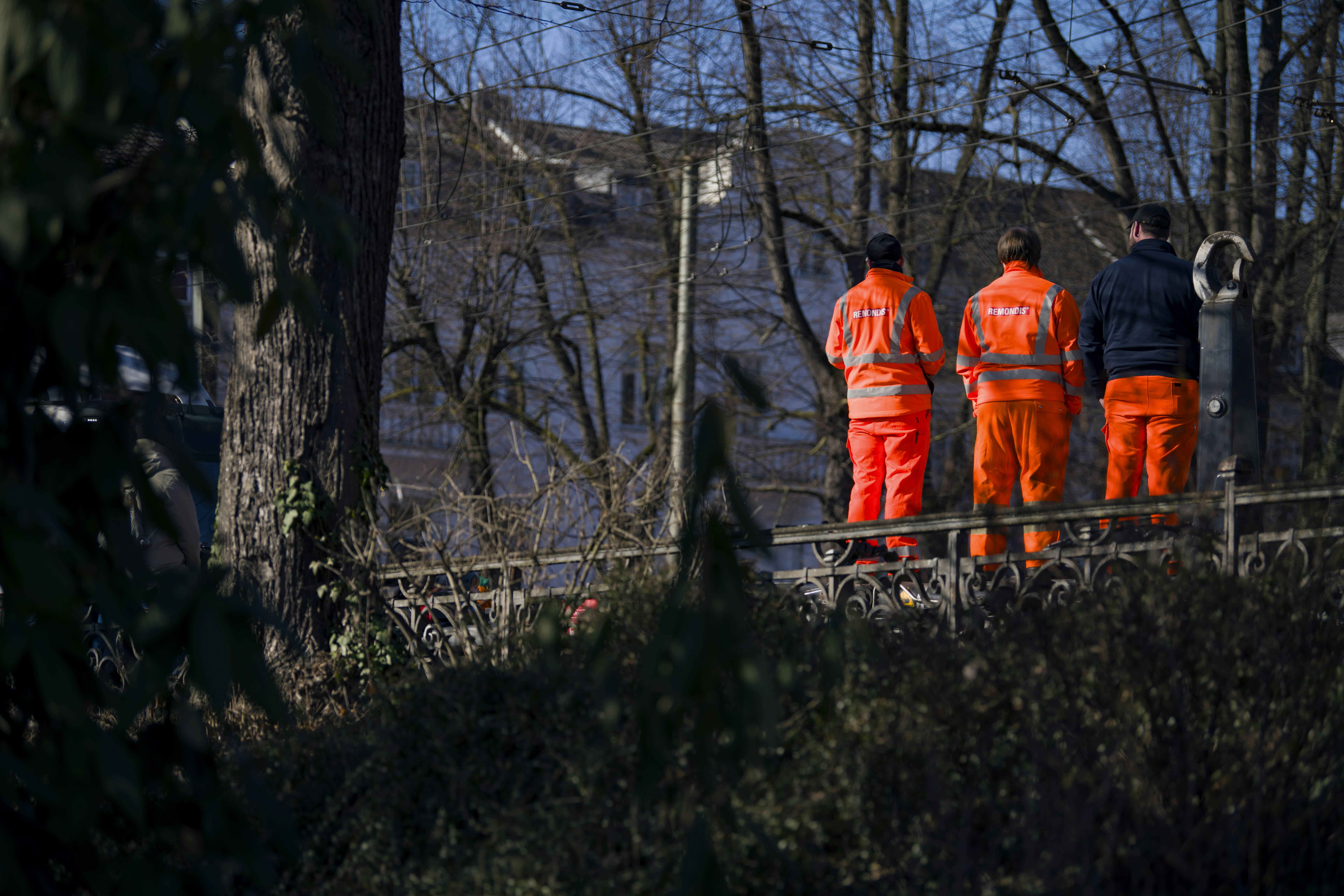 Emergency workers stand near floodwaters.