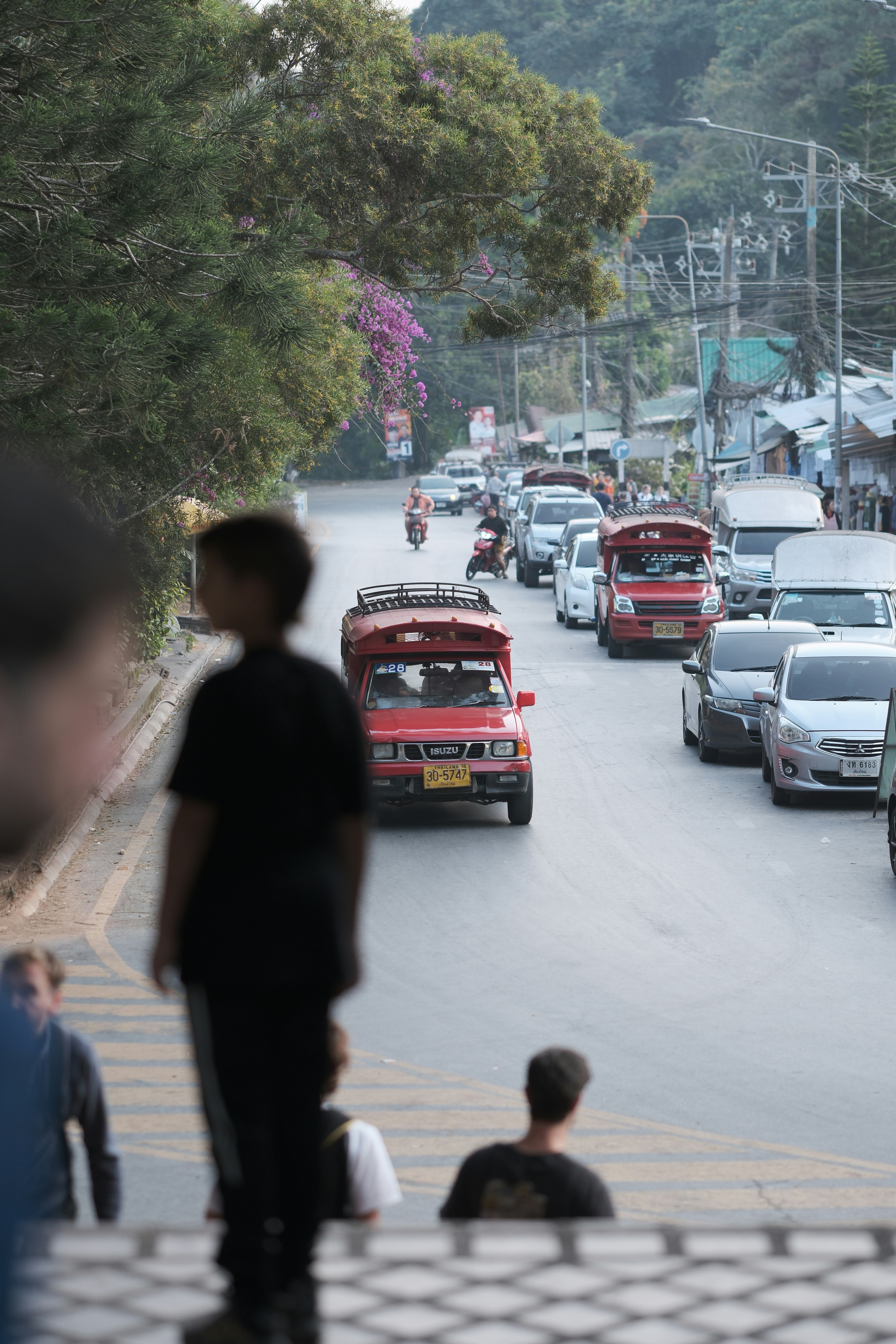 Traffic and people are seen on a busy street.