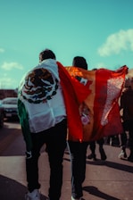 People walk with mexican and spanish flags.