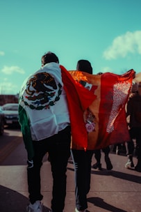 People walk with mexican and spanish flags.
