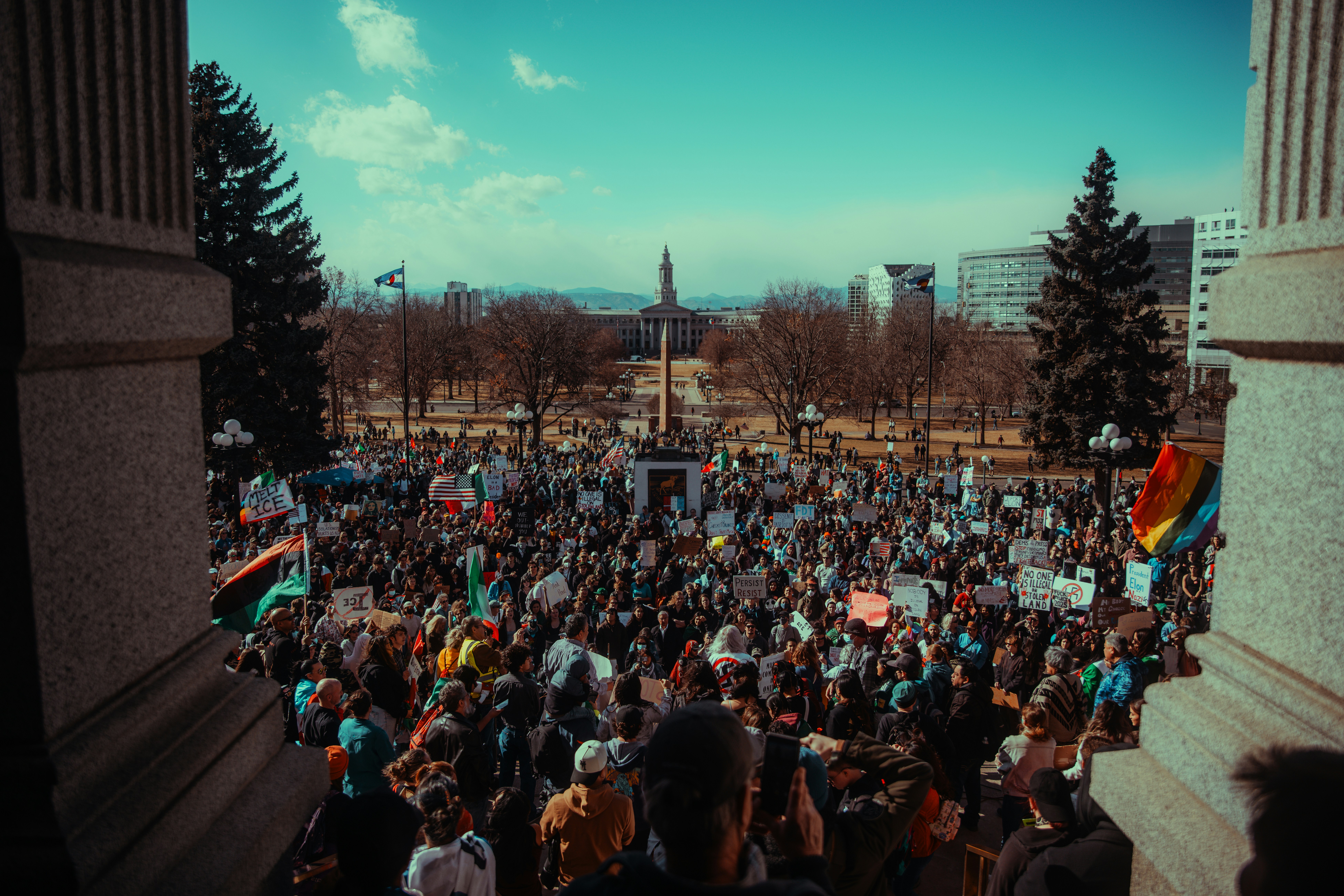 A crowd protests outside of a building.