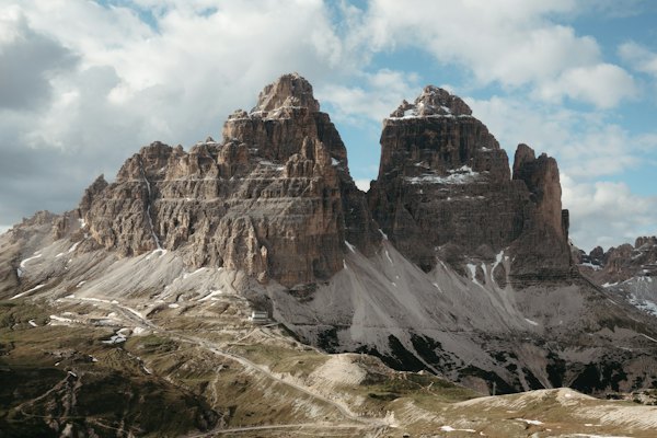 Majestic mountains reach for a cloudy, blue sky — Dolomites, Italy